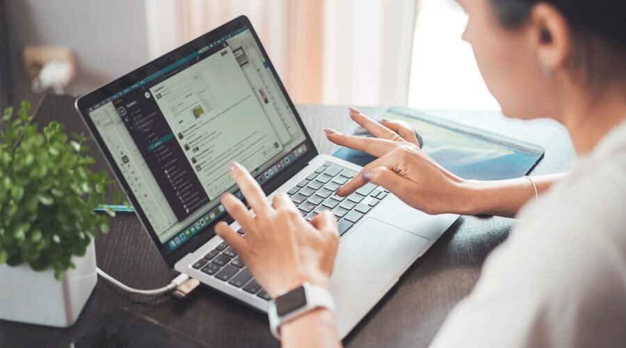 A Lady is working on a laptop and communicating with others with the use of Konversky