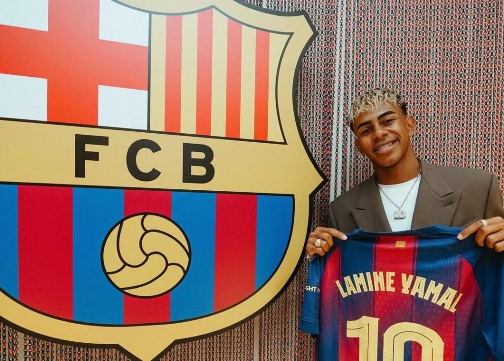 Lamine Yamal holding barcelona jersey