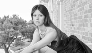 Mia Goth leaning on balcony
